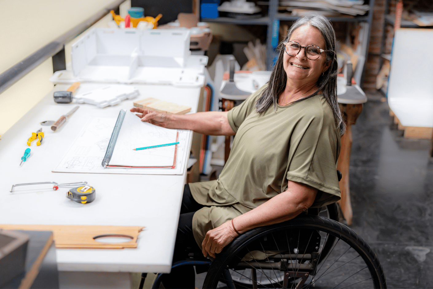 Woman in wheelchair working at a desk in an office.
