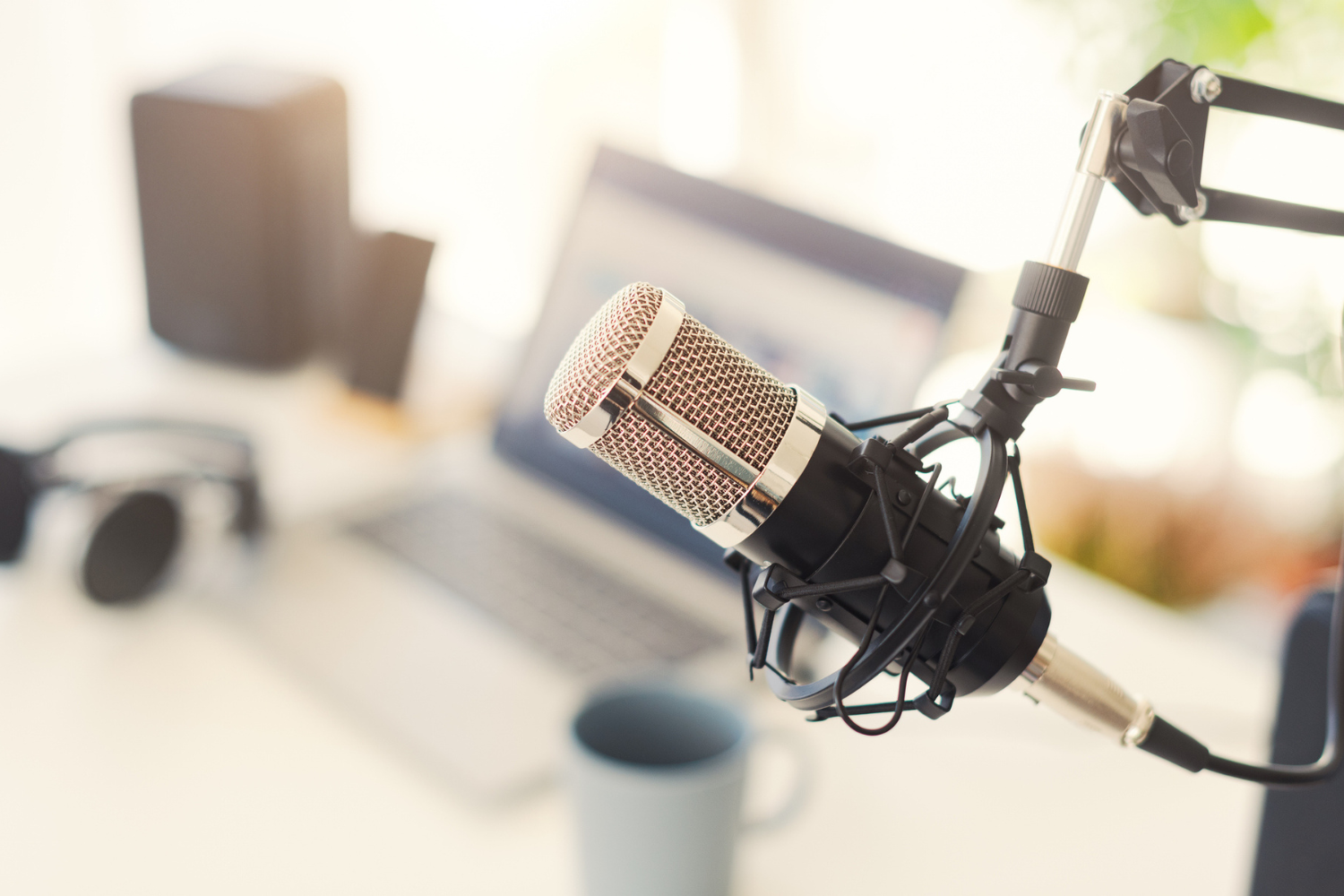Podcast microphone and laptop on a desk.