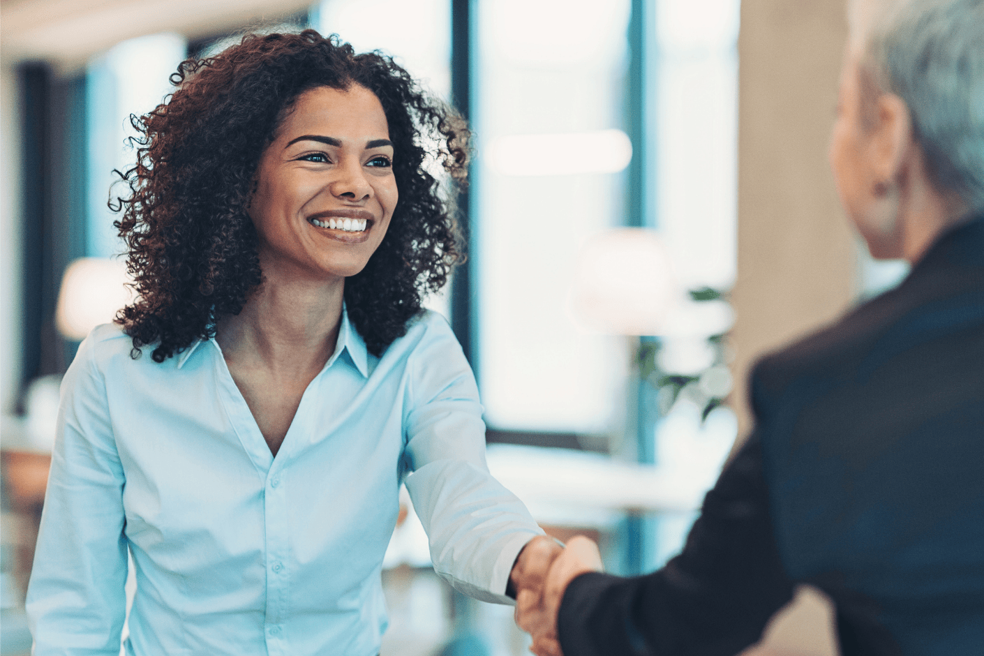 Woman shaking hands in an office.