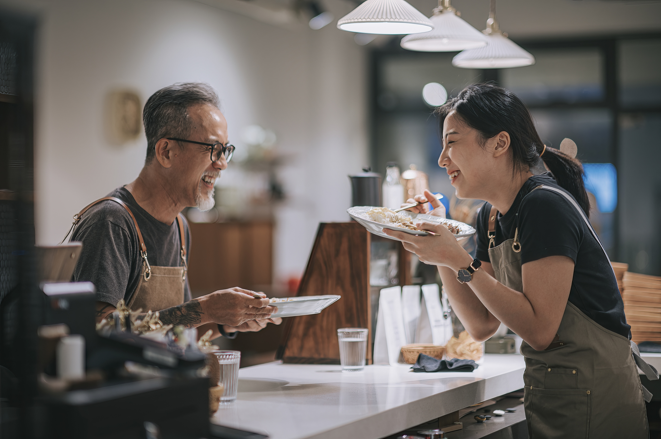 Man and woman taking a break to eat while working at a restaurant.