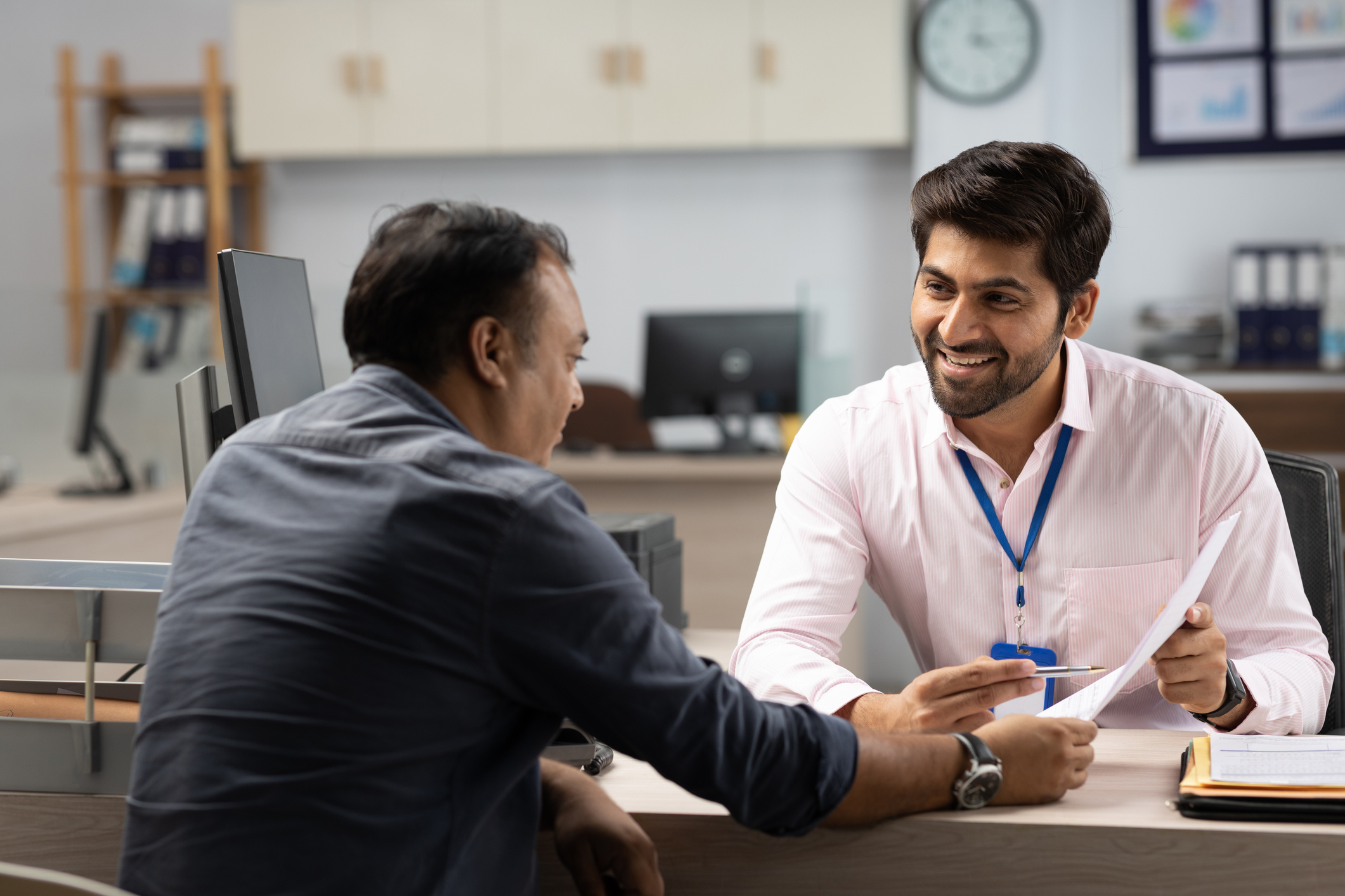 Professional showing a customer important information at his desk.